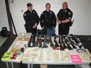 Officers with seized drugs, cash, and guns